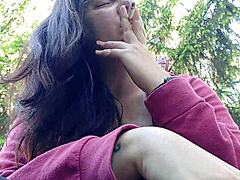 hey nicoletta is smoking outside flashing her big tits by pulling them out in the public garden